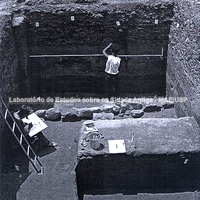 Escavação do Pelópion. Uma pessoa evidenciando o conjunto de pedras pré-históricas.
