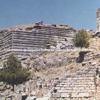Muro do pátio do Templo de Atena, século IV a.C. Ao fundo à direita, vestígios do propileu. Na frente a parede dos fundos da ágora sagrada. Por volta de 130 a.C. 