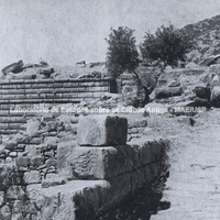 Rua levando ao Templo de Atena (final do século IV a. C.). No centro, à esquerda, muro do teatro do santuário de Atena. Ao fundo, vestígios do Propileu construído no reinado de Augusto. 